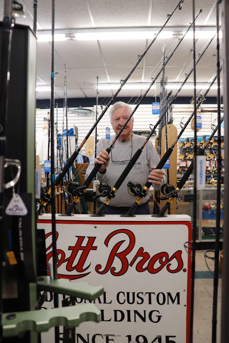 George Lott showing fishing rods in rack