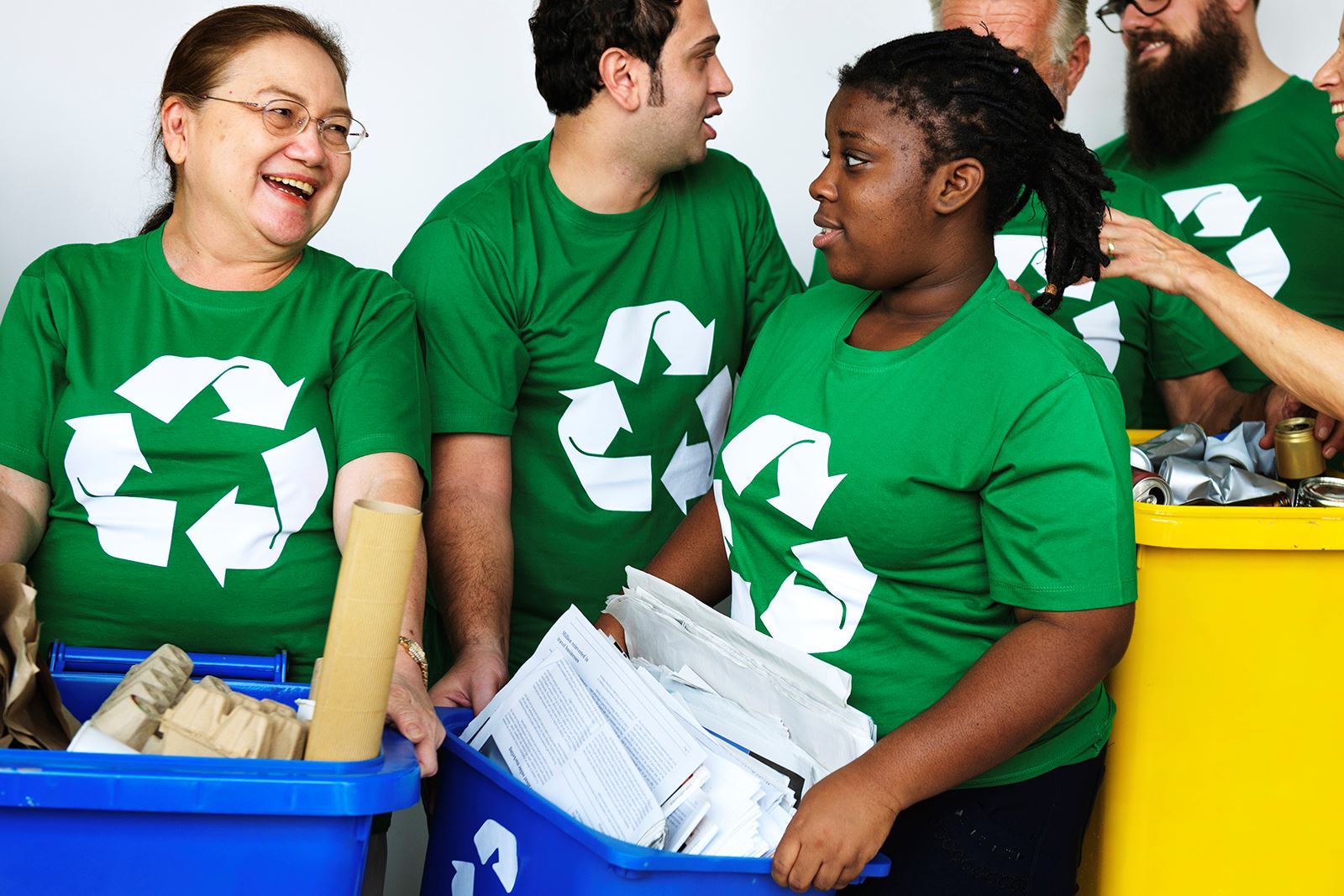 people carrying recycle bins