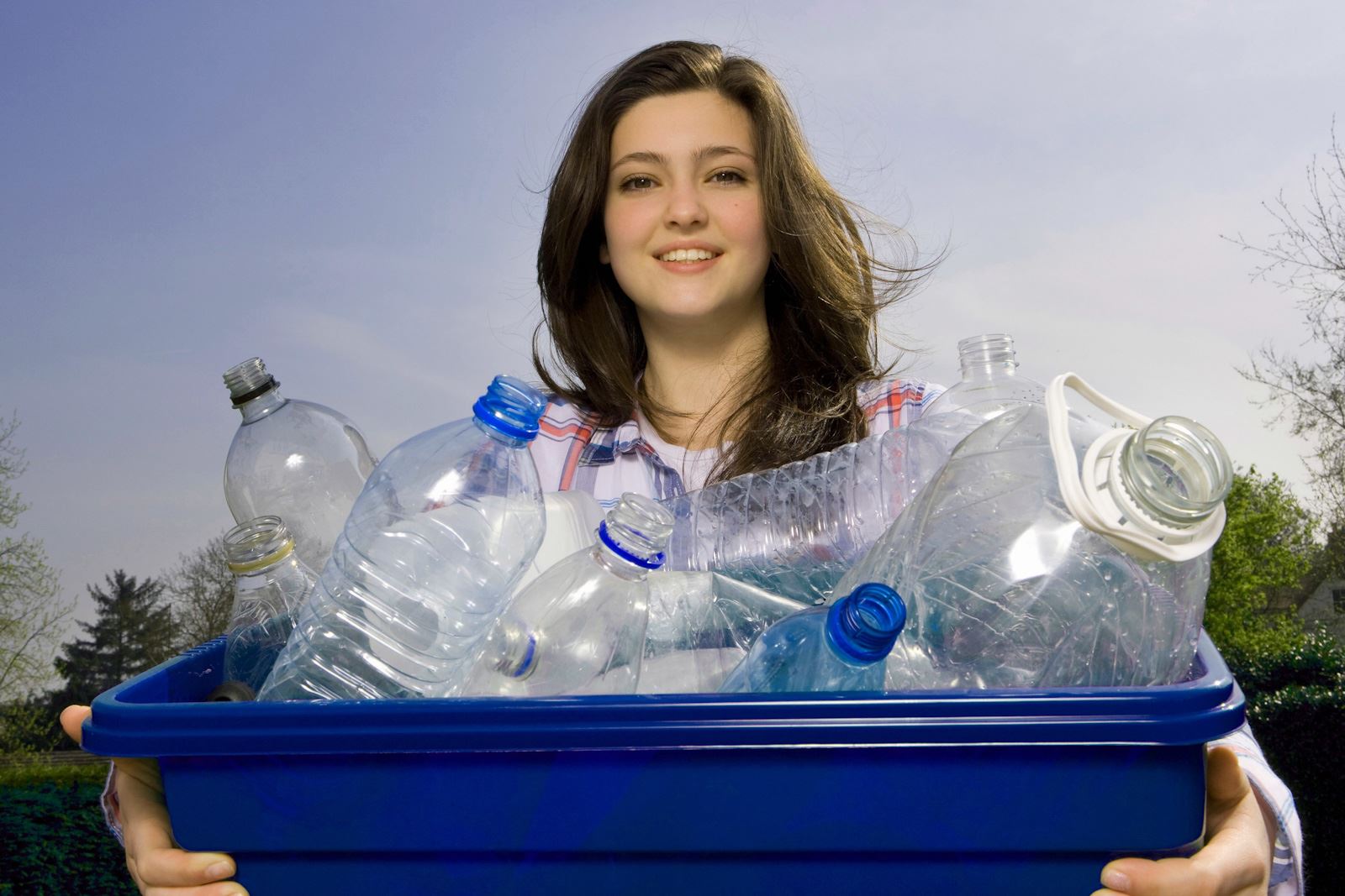 Girl carrying blue recycling bin