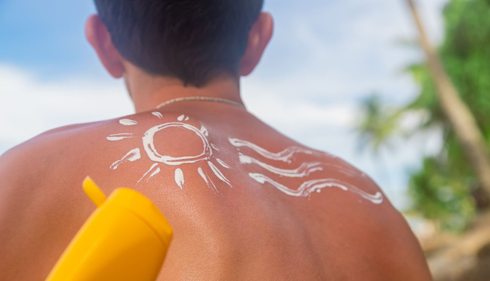 man-on-the-beach-with-sunscreen-on-his-back